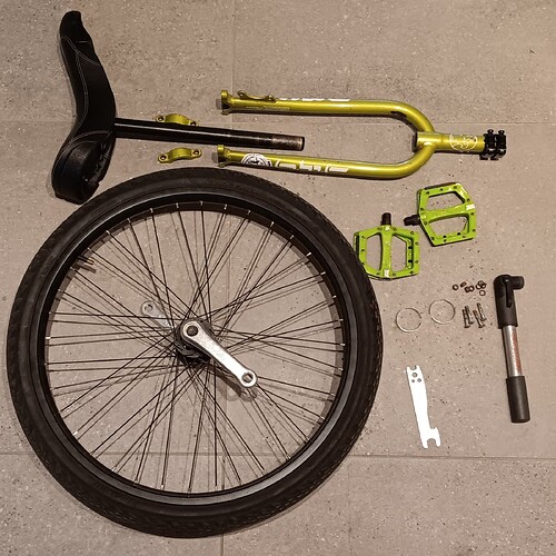 unicycle in parts on a stone tiled floor